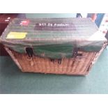 A large wicker laundry hamper with military canvas cover.