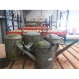 Four galvanised watering cans.