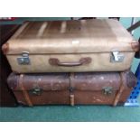 A wood bound travel trunk with a suitcase.