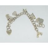 A ladies' silver charm bracelet with six charms.