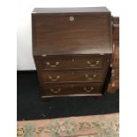 A Mahogany drop-flap bureau fitted three graduated drawers and brass handles.