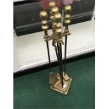 A four piece brass companion set on stand.