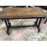 A small mahogany center table on turned supports with geometric inlay to top.