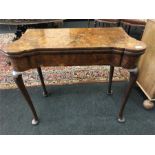 A Queen Anne design walnut fold over top herringbone banded card table, resting on shaped pad