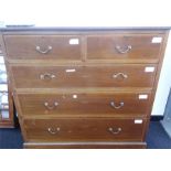 A mahogany satinwood inlaid chest of three long and two short drawers resting on a plinth base.