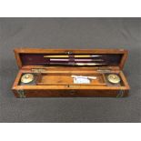 A walnut pen case with inkwells and pens.