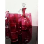 A cranberry glass claret decanter with pulled handles, water jug and six tumblers and other mixed