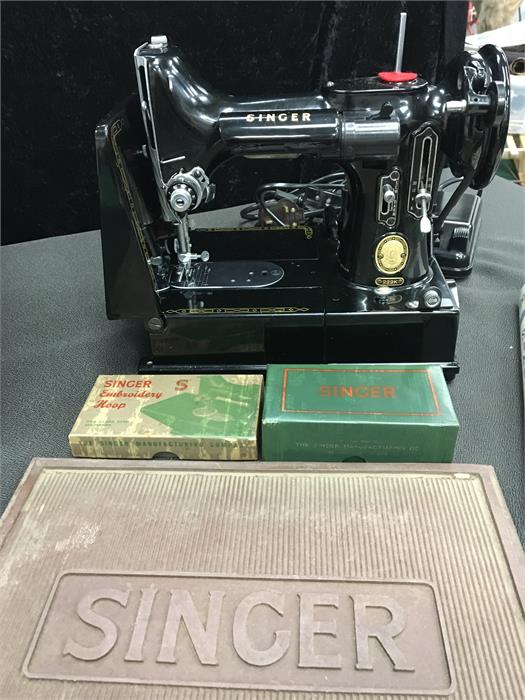 A small Singer electric sewing machine, Model 222K together with accessories including rubber mat,