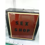 A light up red 'Sex Shop' sign.