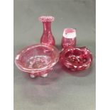 Four pieces of cranberry glass.