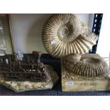 Two large cast ammonites, with a stone set metal train.