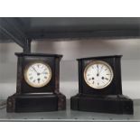 Two Victorian black slate mantle clocks with enamel dials and Roman numerals.