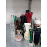 A large collection of glass vases of various shapes and colours.