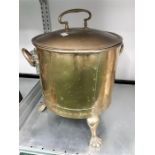 A two handled copper coal bucket on three legs.