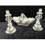 Moore Brothers Cupid candlesticks together with a floral encrusted bowl. (af)