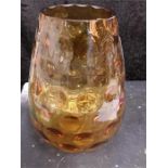 A large amber coloured dimpled glass vase.