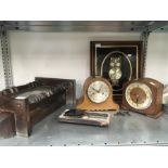 Two mantle clocks together with a framed owl clock and a wall clock.