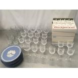 A collection of cut glass wine glasses and twenty Jasperware Christmas plates.