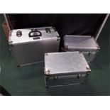 Three silver coloured cases, Logicline trunks and flight cases made in England.