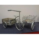 Two metal garden items depicting a bicycle with flower barrow.