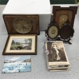 A cuckoo clock with wooden picture frames and vintage postcards.