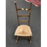 A rush seated rocking chair by Liberty & Co Goodyers or voisey