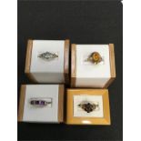 Four ladies dress rings set with various stones.