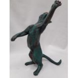 A resin cat figure in a reach pose.