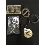 A silver fronted address book , three metal bangles, a mother of pearl pendant and a brass abacus.