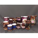 A collection of English lustre ware jugs with relief decoration and cups. etc