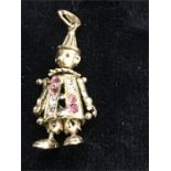 An articulated gold charm in the form of a clown set with pink and white stones.