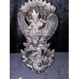 A carved oriental wooden sculpture of a goddess on a stylised dragon