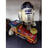 A battery operated R2-D2 together with a tin plate battery operated train.