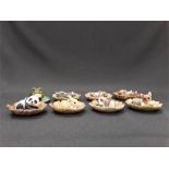 A collection of miniature ceramic animals displayed on ceramic leaves.