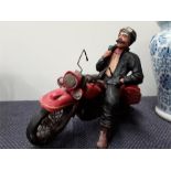 A resin ornament depicting a man on a motorbike.