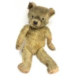 Straw filled teddy bear with disc joints and small hump to back. Height 52cm. Well-loved, several