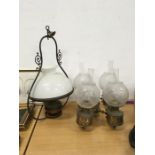 A central hanging oil lamp with white glass shade together with a pair of wall oil lights