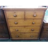 A five drawer chest resting on a plinth base.