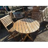 A folding wooden bistro table and two chairs.