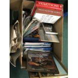 A box containing books, magazines, maps and pictures.