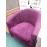 A tub chair upholstered in purple velour.