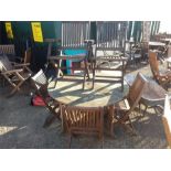 A circular garden table and six folding chairs.