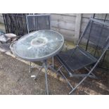 A metal and glass bistro garden table with two folding chairs.