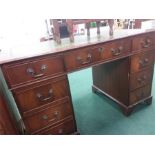 A reproduction twin pedestal desk with inset green leatherette top.