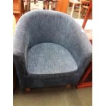 A tub chair upholstered in blue velour.