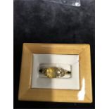 A 9ct gold ring with central yellow stone.