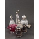 Four silver topped glass cologne bottles with binoculars, metal dog and a piece of cranberry glass.