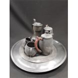 A pewter charger, tappit hen Art Nouveau, four piece pewter tea set and a circular plate.