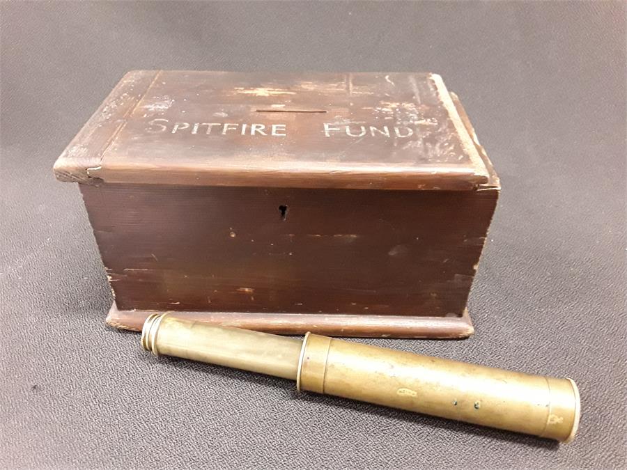 A WWII 'Spitfire Fund' box with a telescope.