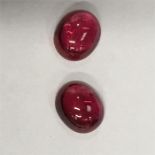 Two cabochon cut ruby coloured stones.